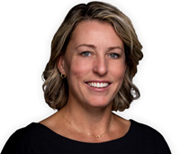Woman with shoulder length brown hair wearing a black shirt smiling.